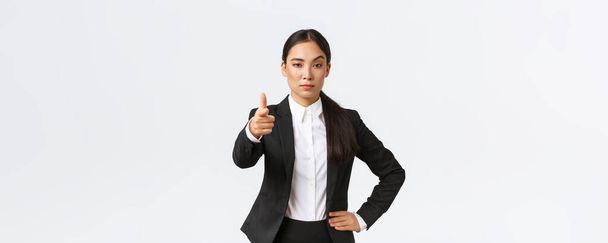 Упевнений суворий офісний менеджер, азіатська жінка-підприємець вказує пальцем на камеру і виглядає серйозно, пропонує пропозицію роботи, дає завдання, вибирає співробітника для роботи, стоїть на білому тлі
 - Фото, зображення