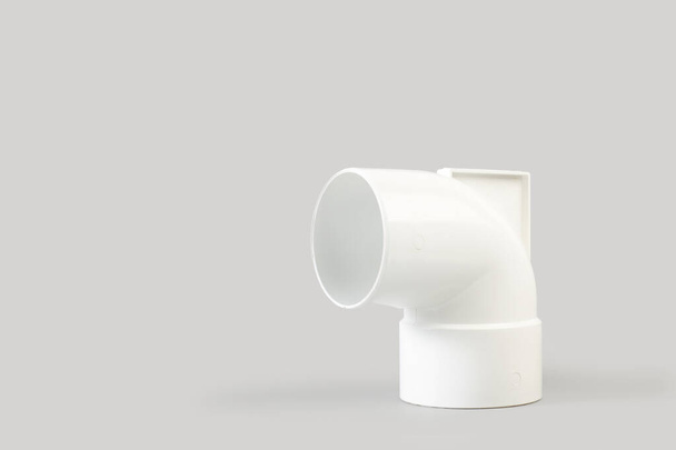 White plastic connection pipe on a gray background with copy space - Valokuva, kuva