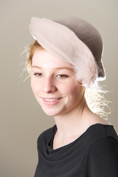 Sonriente pelirroja con sombrero de color topo mirando hacia abajo
 - Foto, Imagen