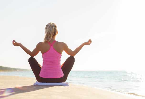 Silhouette de jeune femme en bonne santé et en forme pratiquant le yoga sur la plage
 - Photo, image