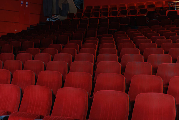 Sessel in einem dunklen Kino. Hintergrund mit Kopierraum für Text oder Beschriftungen. Eine leere Halle ohne Menschen. - Foto, Bild