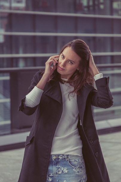 Pretty girl talking on phone in the city streets - Fotó, kép