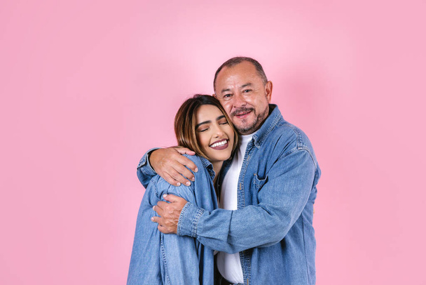 pai e filha latinos em roupas casuais em um espaço de cópia em fundo rosa no México América Latina - Foto, Imagem
