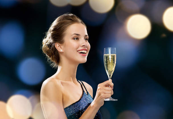 smiling woman holding glass of sparkling wine - Фото, изображение