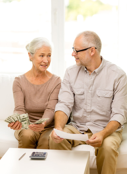 senior couple with money and calculator at home - Foto, immagini