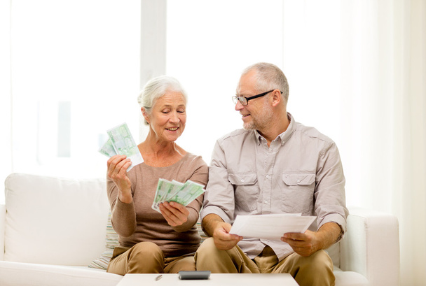 senior couple with money and calculator at home - Foto, imagen