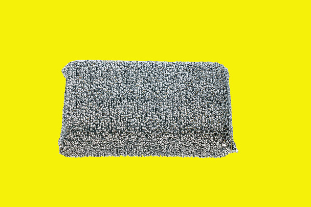 A typical classic silver dish sponge with polyester thread on a yellow isolated background. Strong and durable, eliminates difficult pollution, dries quickly. - Photo, Image