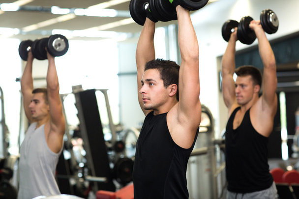 group of men with dumbbells in gym - Foto, imagen