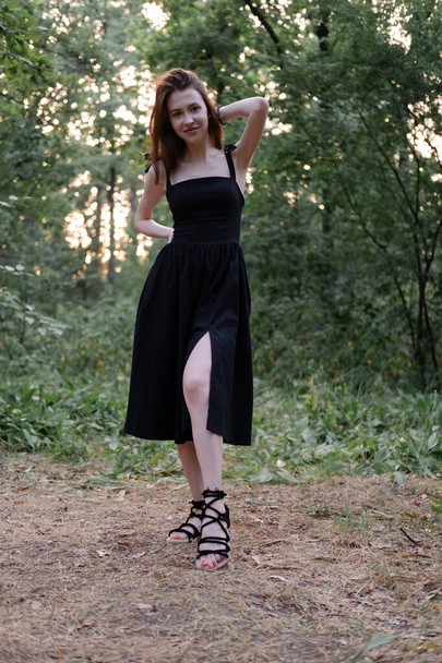 portrait of sensual young woman in a black dress in the forest. freedom, loneliness. nature loving. - Photo, Image