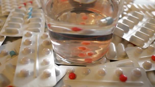 8K 7680x4320.Léky pilulky ve skle.Červené léky tavení ve vodě.Smíšené léky v jejich balení a otevřené.Léky packs.Pharmaceutical průmyslu nezdravé.Látka zneužívání.Lékárna tablet 8K - Záběry, video