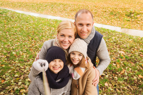 happy family with selfie stick in autumn park - Zdjęcie, obraz