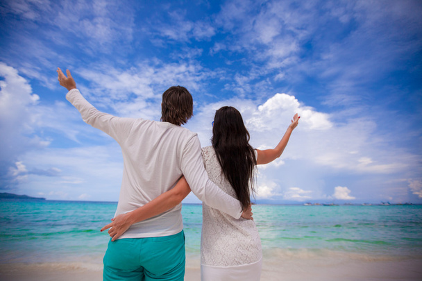 Visão traseira do jovem casal na praia branca
 - Foto, Imagem