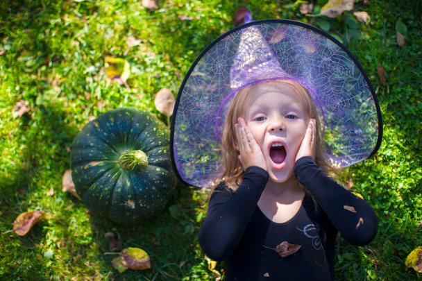 Cute little girl in Halloween which costume have fun outdoor - Фото, изображение
