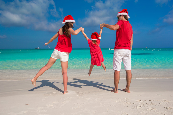 Heureuse famille de trois personnes dans Chapeaux de Noël pendant les vacances tropicales
 - Photo, image