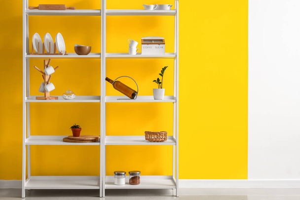 Moderna scaffalatura con stoviglie vicino alla parete a colori in cucina - Foto, immagini