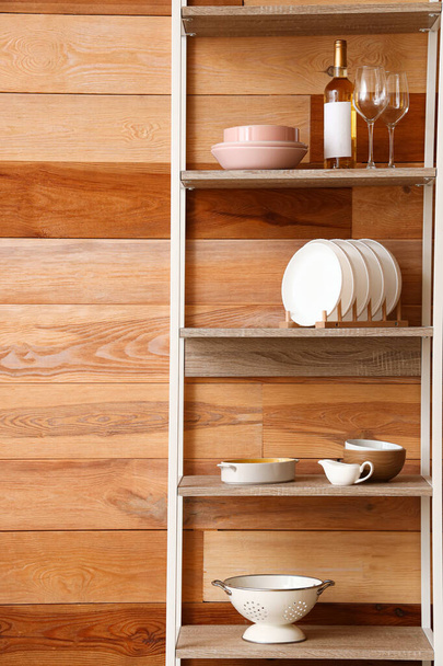 Scaffale moderno con stoviglie vicino alla parete in legno in cucina, primo piano - Foto, immagini