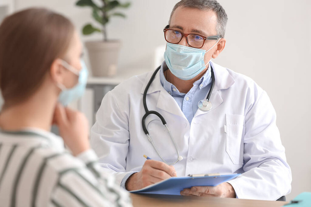 Ill woman with sore throat visiting doctor in clinic - Foto, Bild