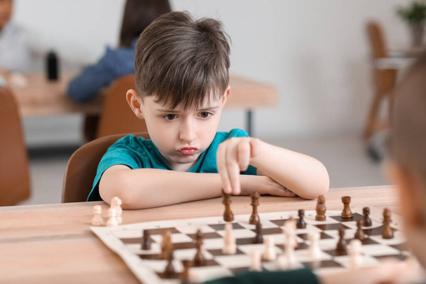 Little boy playing chess during tournament in club - Fotoğraf, Görsel