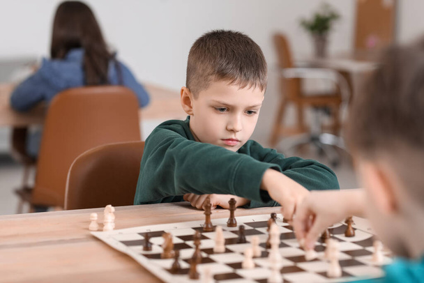 Little children playing chess during tournament in club - Foto, Imagem