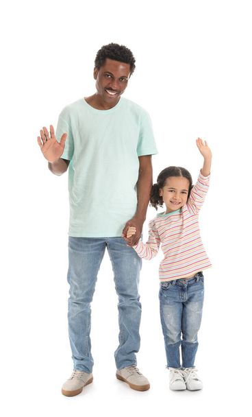 Портрет щасливого афро-американського чоловіка і його маленької дочки, що махає руками на білому тлі. - Фото, зображення