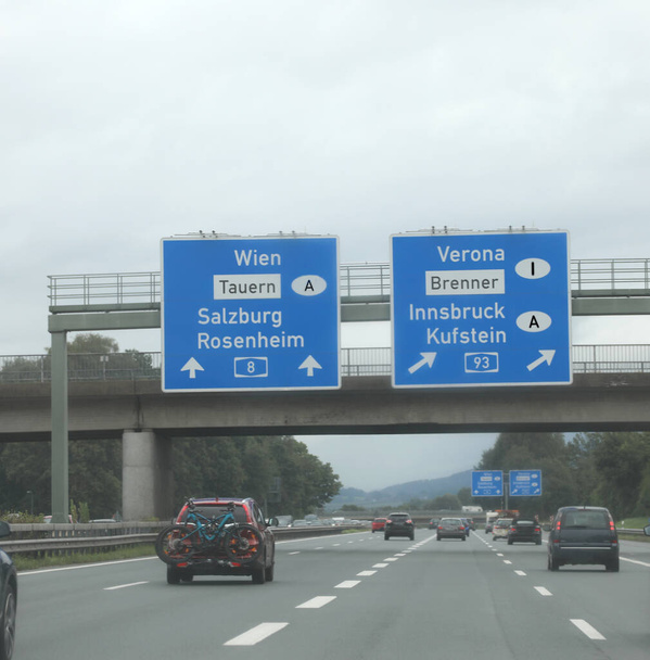 auto in alta quota con svincolo autostradale con grandi cartelli che indicano le città di confine in austria e Italia - Foto, immagini