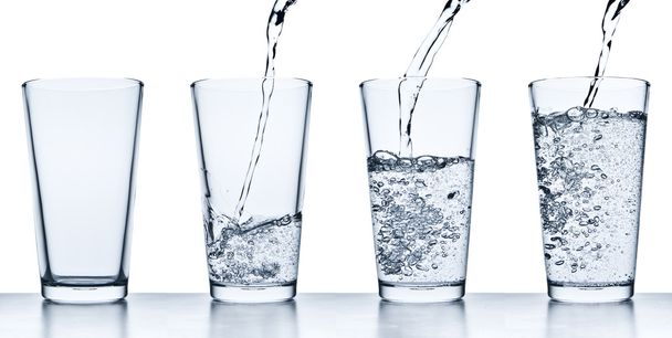 gieten van water in glas - Foto, afbeelding