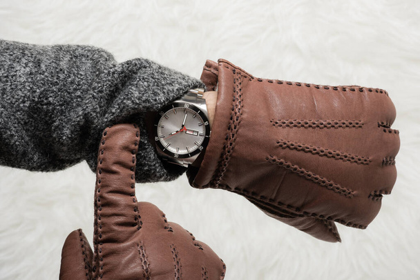 mężczyzna patrząc czas na jego zegarek w zimie. - Zdjęcie, obraz