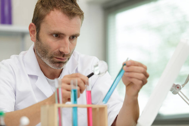 male researcher holding a test tube - Фото, изображение