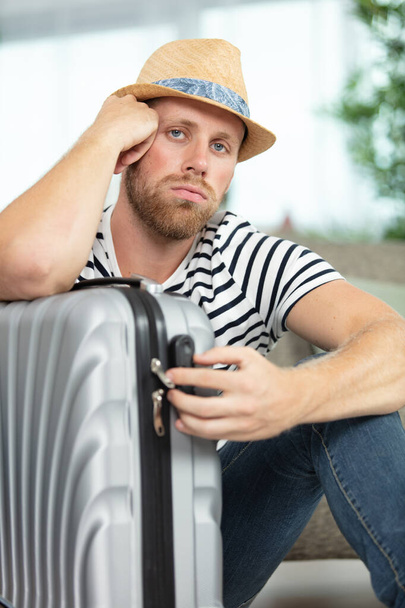 Unglücklicher Mann saß mit seinem Koffer - Foto, Bild