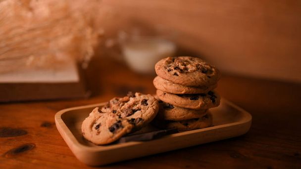 クローズアップ画像,木製テーブルの上においしいチョコレートチップクッキーの木製プレート背景.  - 写真・画像