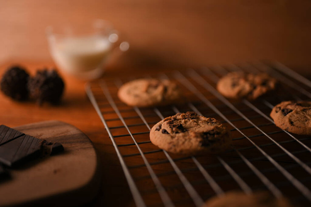 Imagem de close-up, biscoitos de chocolate recém-assados ou biscoitos de manteiga de amendoim com pedaços de chocolate em um rack de resfriamento. - Foto, Imagem