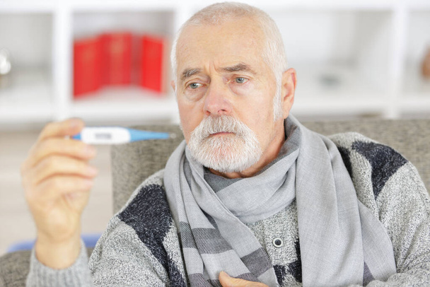 senior man checking body temperature with thermometer - Photo, Image