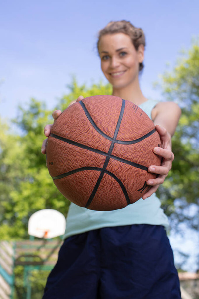happy female athlete standing with basketball - Zdjęcie, obraz