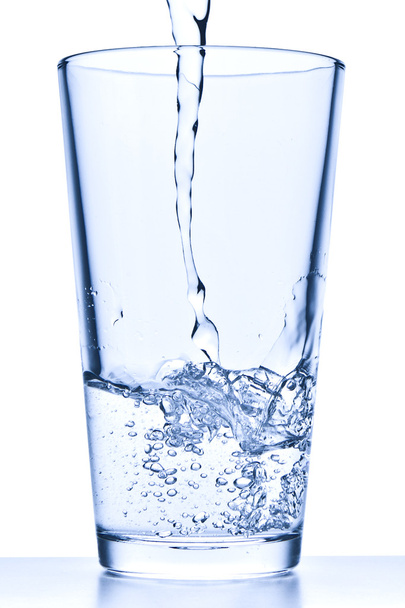 gieten van water in glas - Foto, afbeelding