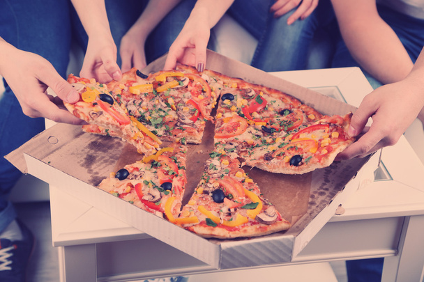 молодые друзья едят пиццу
 - Фото, изображение