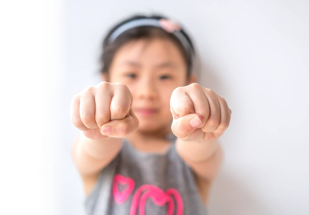 litter girl showing her fist, let you guest - 写真・画像