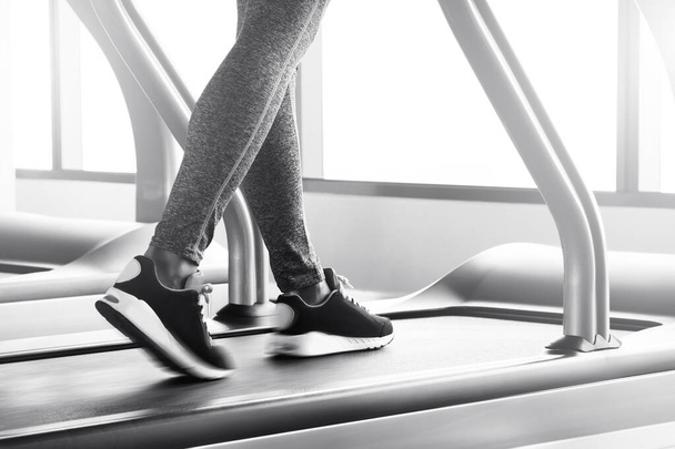 Close up of walking female legs on a treadmill with motion blur effect  - Фото, изображение