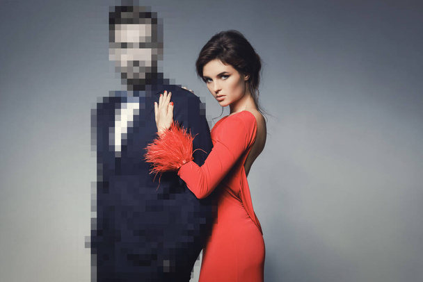 Concepto de citas online. Encuentra tu amor en internet. Hermosa mujer con vestido rojo en abrazo con un hombre irreconocible. - Foto, imagen