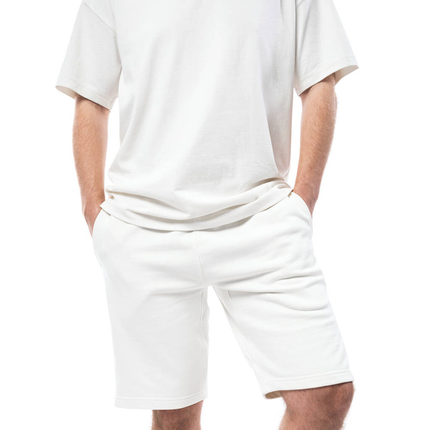 Man wearing blank white t-shirt and shorts isolated on white background - Фото, изображение