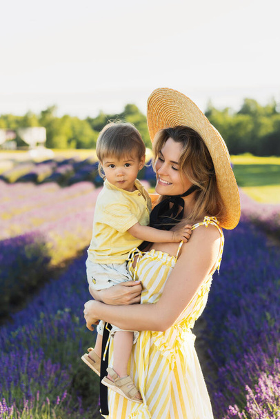 Beautiful young woman and her cute little son in the lavender field - Fotografie, Obrázek