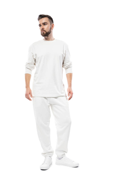 Handsome man wearing white long-sleeved t-shirt and pants isolated on white background - Foto, Bild