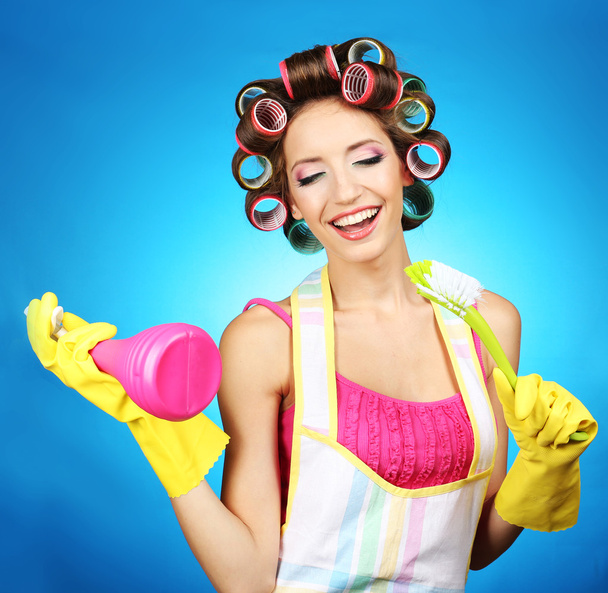 Beautiful girl in hair curlers on blue background - Фото, изображение