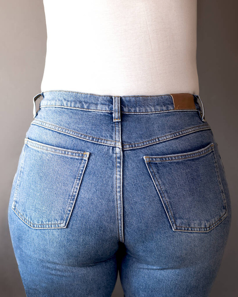 Vista posteriore di una donna che indossa jeans blu a vita alta. Concetto Denim Day Holiday. Copia spazio. - Foto, immagini