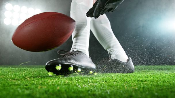 American football player kicking ball on grass., detailed shot. Football background. - Zdjęcie, obraz
