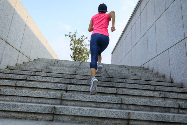 Fitness sports woman running up stairs in city - 写真・画像
