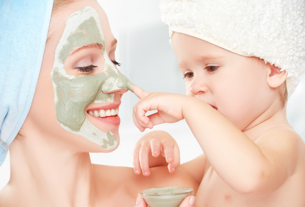 浴室で家族の美容トリートメント。母と娘の赤ちゃん女の子が作る顔の皮膚のマスク - 写真・画像
