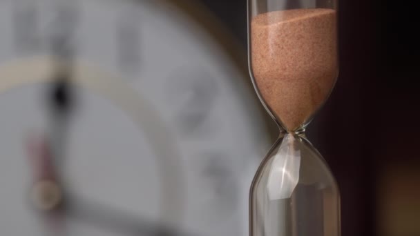 Zandloper Close-up giet tegen de achtergrond gewoon mechanisch horloge - Video