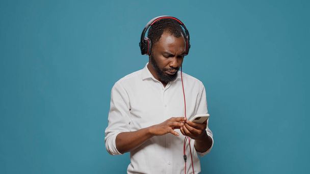 Fiatal személy hallgat hangot a fejhallgató mobiltelefonnal - Fotó, kép