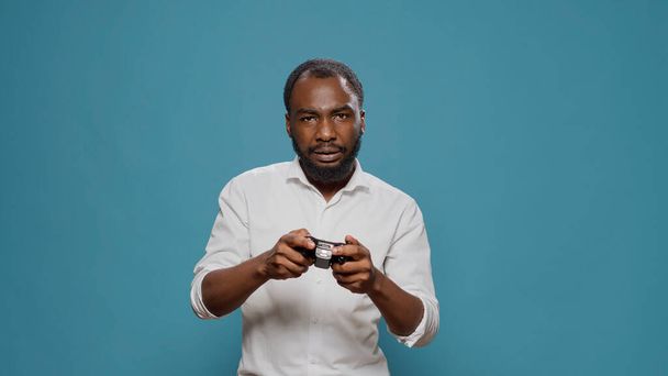 Persona moderna usando el controlador para jugar videojuegos en el estudio - Foto, Imagen