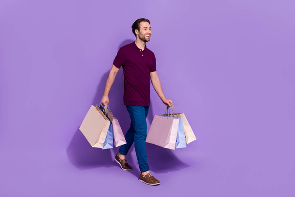 Full size photo of trend millennial brunet guy do shoppping go wear t-shirt trousers shoes isolated on purple background - Foto, imagen
